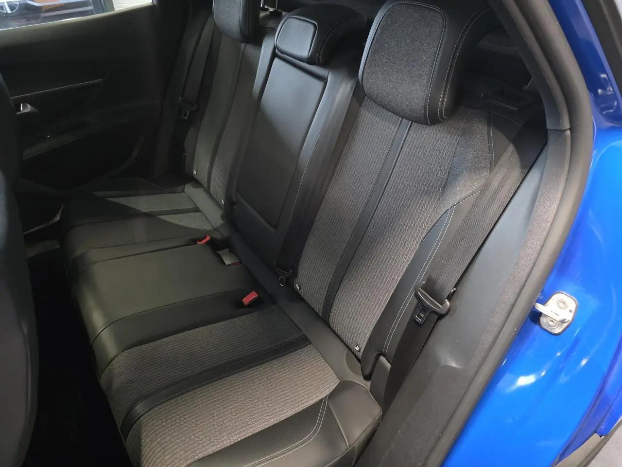 Vue côté droit de la banquette arrière en tissu et cuir du Peugeot 3008 Bleu Iron avec porte ouverte.
