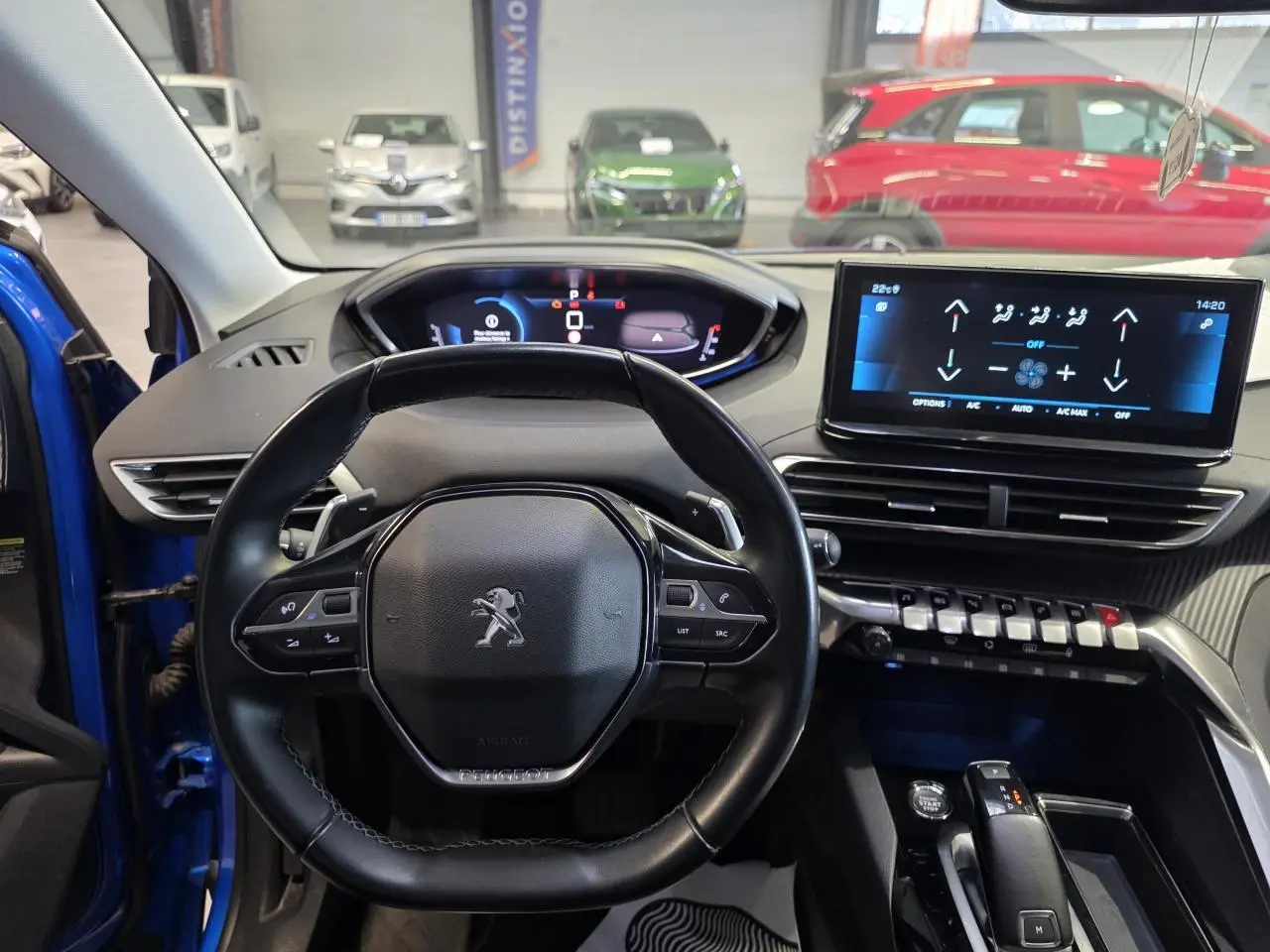 Vue intérieure centrée sur le volant cuir noir et le tableau de bord numérique du Peugeot 3008 Bleu Iron 2022.