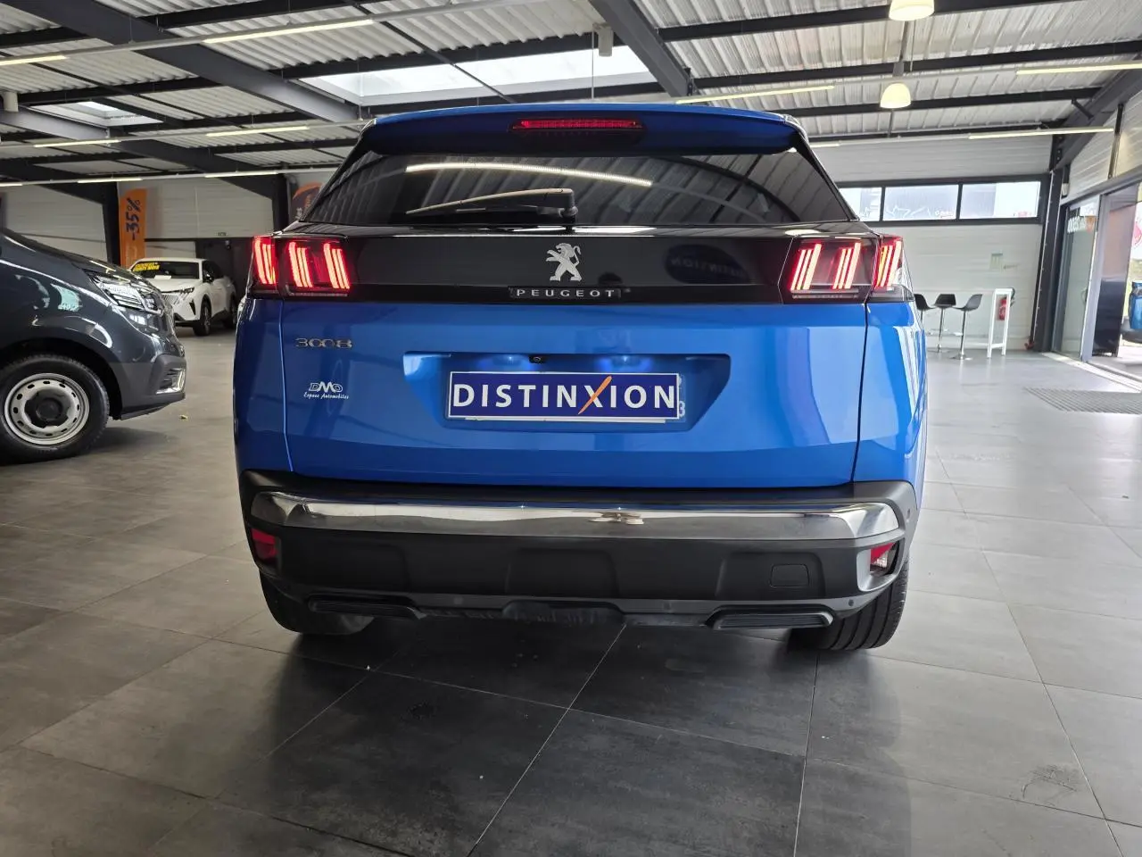 Vue arrière du Peugeot 3008 bleu Iron avec feux LED caractéristiques et bandeau noir brillant au-dessus du coffre.