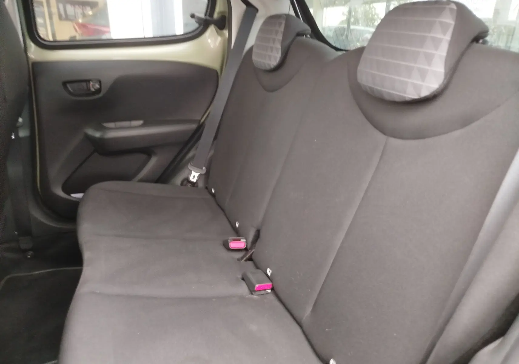 Vue intérieure côté gauche des sièges arrière noirs avec appuie-têtes gris à motifs dans une Peugeot 108 Smooth Green 2021.
