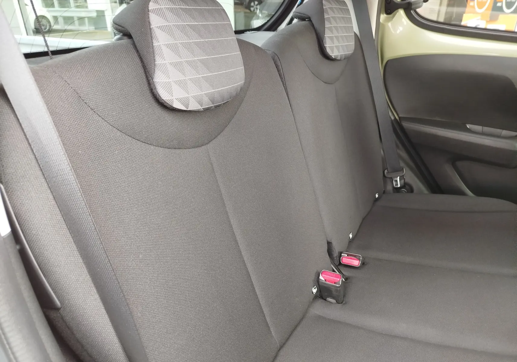 Vue intérieure côté droit des sièges arrière noirs avec appuie-têtes à motifs géométriques de la Peugeot 108 Smooth Green 2021.