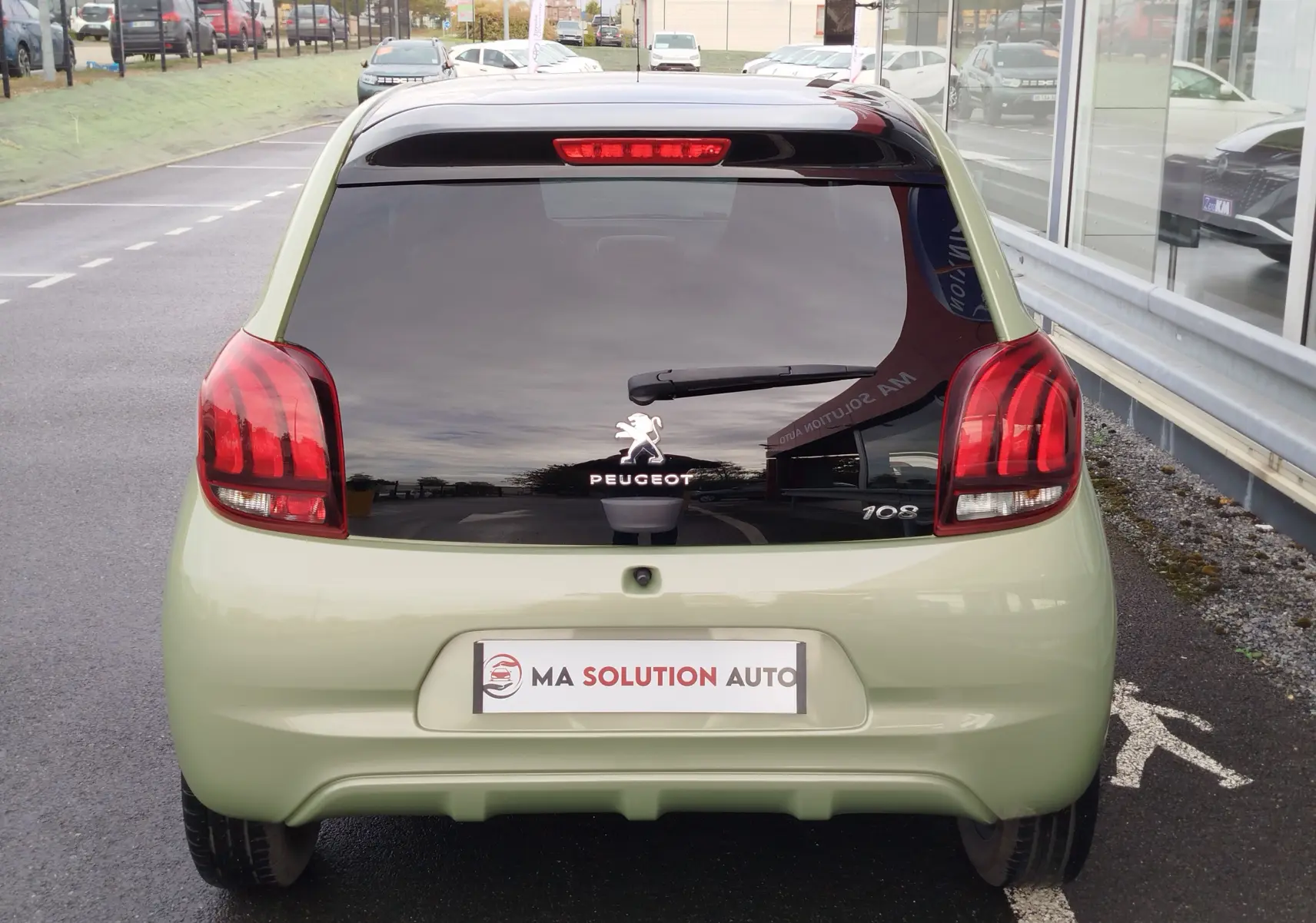 Vue arrière d'une Peugeot 108 Smooth Green 2021 avec lunette arrière noire et feux arrière rouges distinctifs.