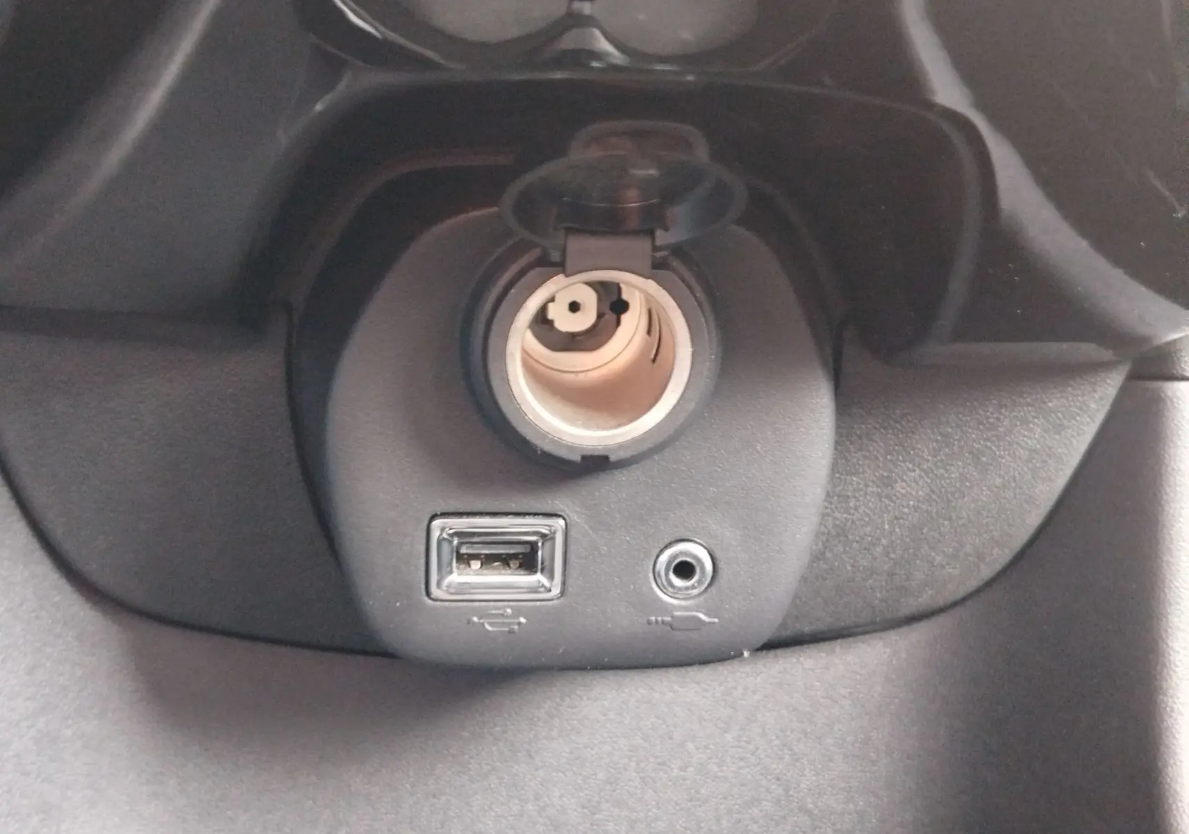 Vue rapprochée de la prise allume-cigare, port USB et entrée auxiliaire du Peugeot 108 2021 en Smooth Green.