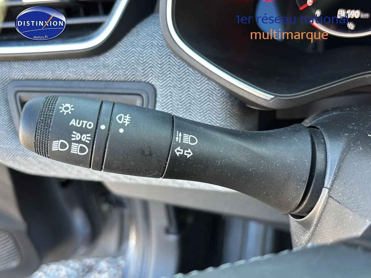 Le commodo des phares et clignotants sur le côté gauche du tableau de bord d'une Renault Clio V gris pizzara.