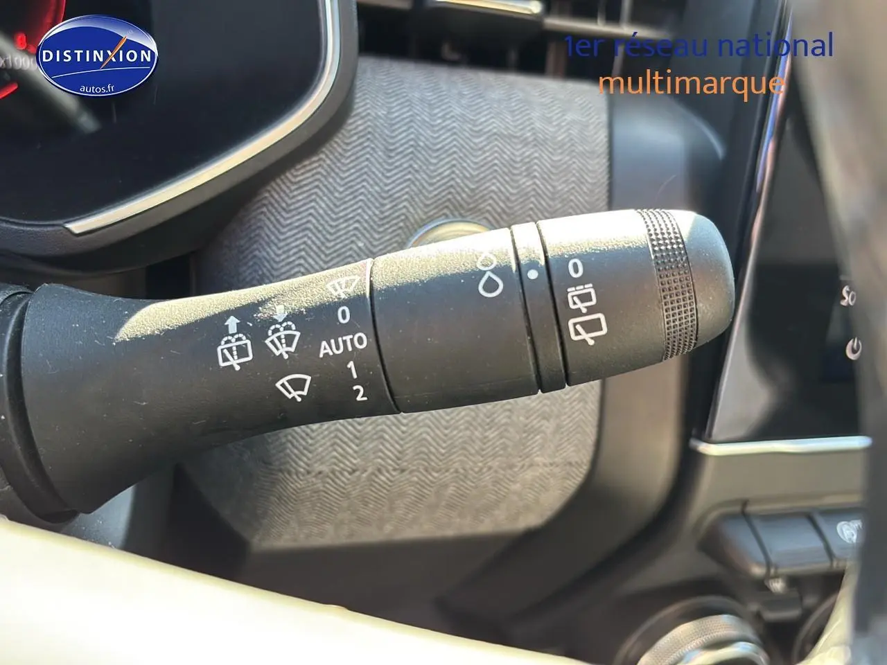 Gros plan sur la commande des essuie-glaces dans l'habitacle de la Renault Clio V gris pizzara 2024.