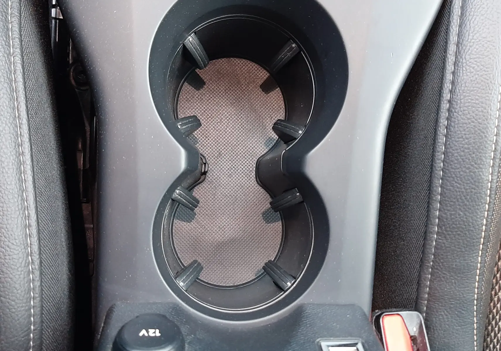 Gros plan sur le porte-gobelets central noir et la prise 12V dans l'habitacle du DS3 Crossback 2019.