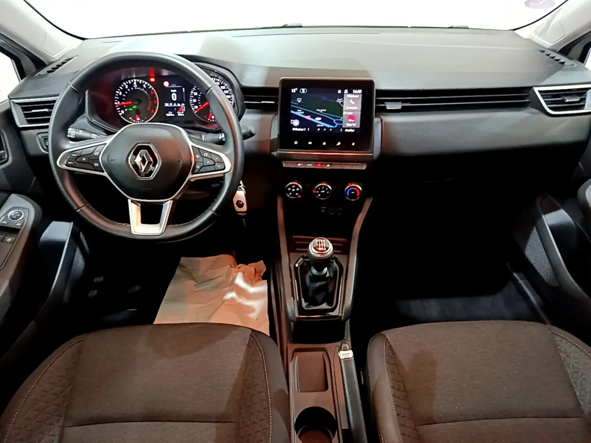 Vue intérieure avant de la Renault Clio Business TCe 90 2021, tableau de bord noir avec écran tactile central et volant multifonctions.