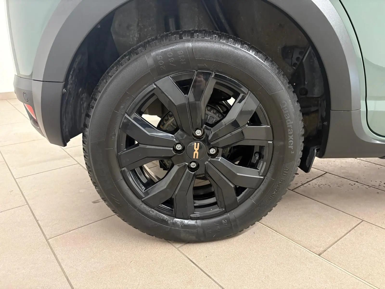 Gros plan sur la roue arrière droite noire brillante du Dacia Sandero Stepway Vert Cèdre avec attelage visible.