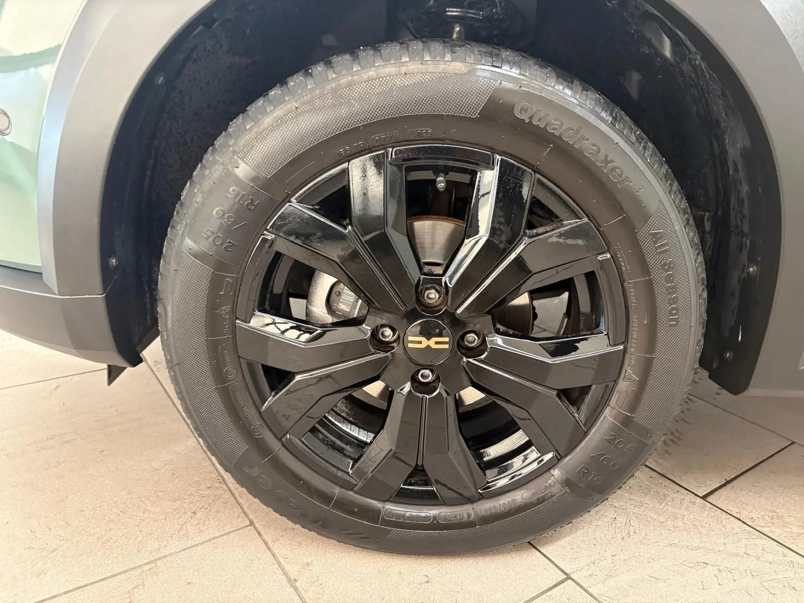 Gros plan sur la roue avant droite noire brillante du Dacia Sandero Stepway Vert Cèdre avec jante spécifique 2023.