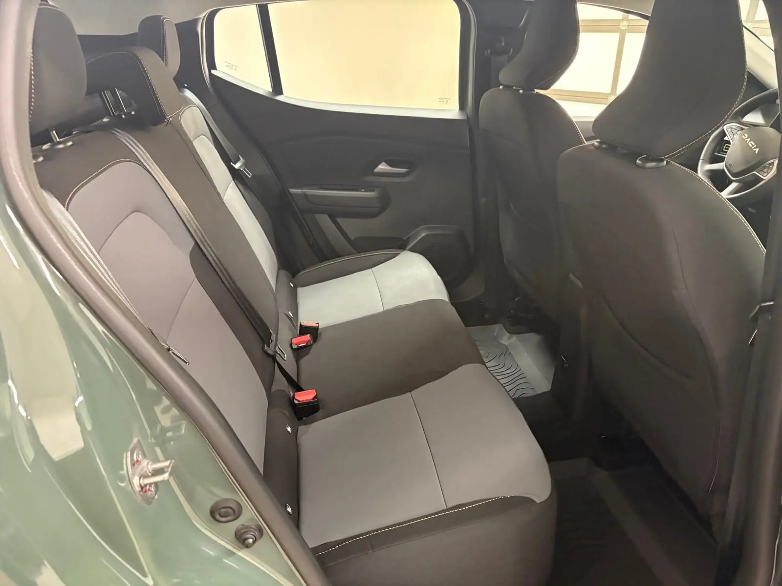 Vue intérieure côté gauche montrant la banquette arrière grise et noire du Dacia Sandero Stepway Vert Cèdre 2023.
