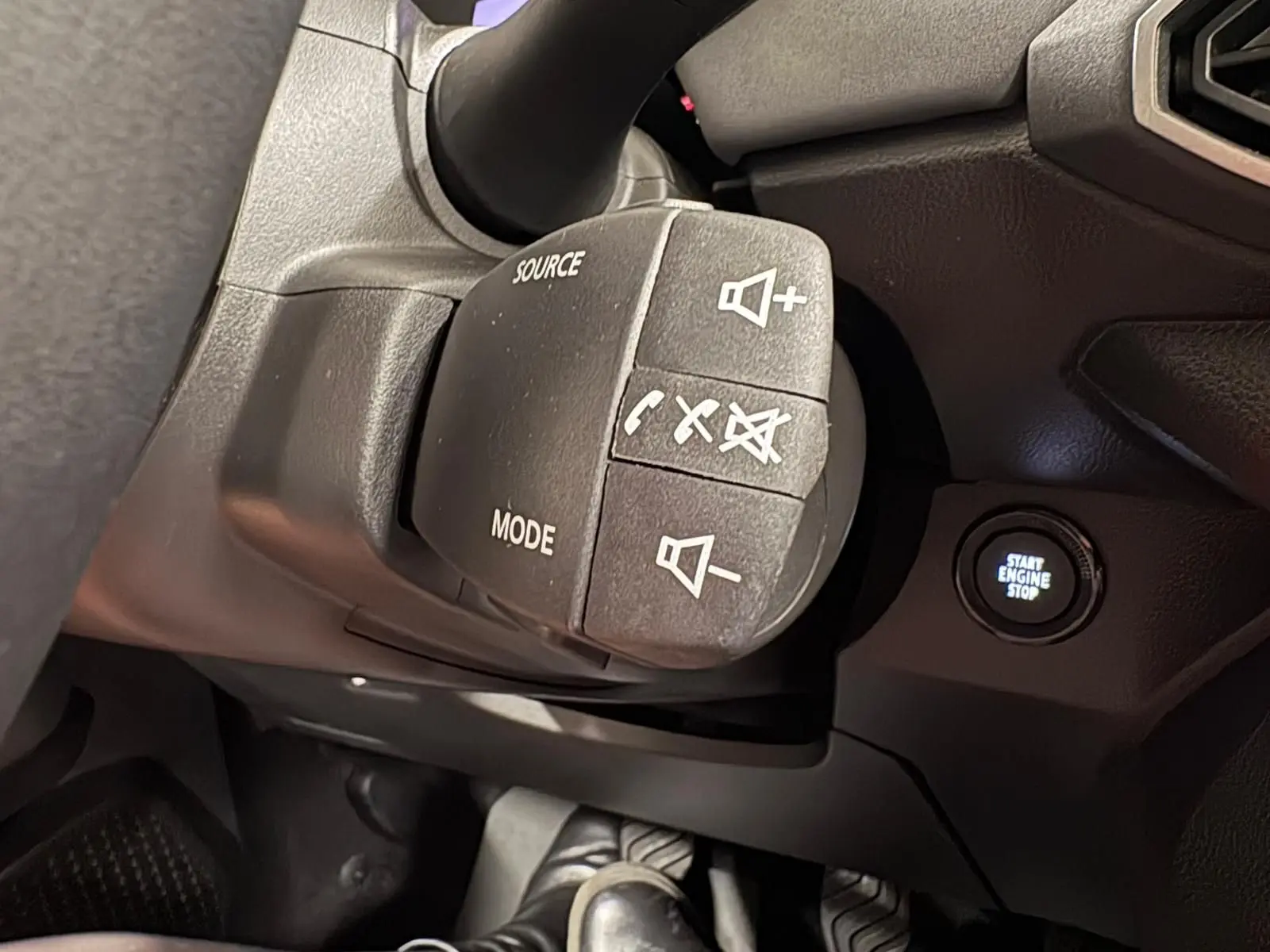 Gros plan sur la commande au volant et le bouton start/stop du tableau de bord du Dacia Sandero Stepway 2023.