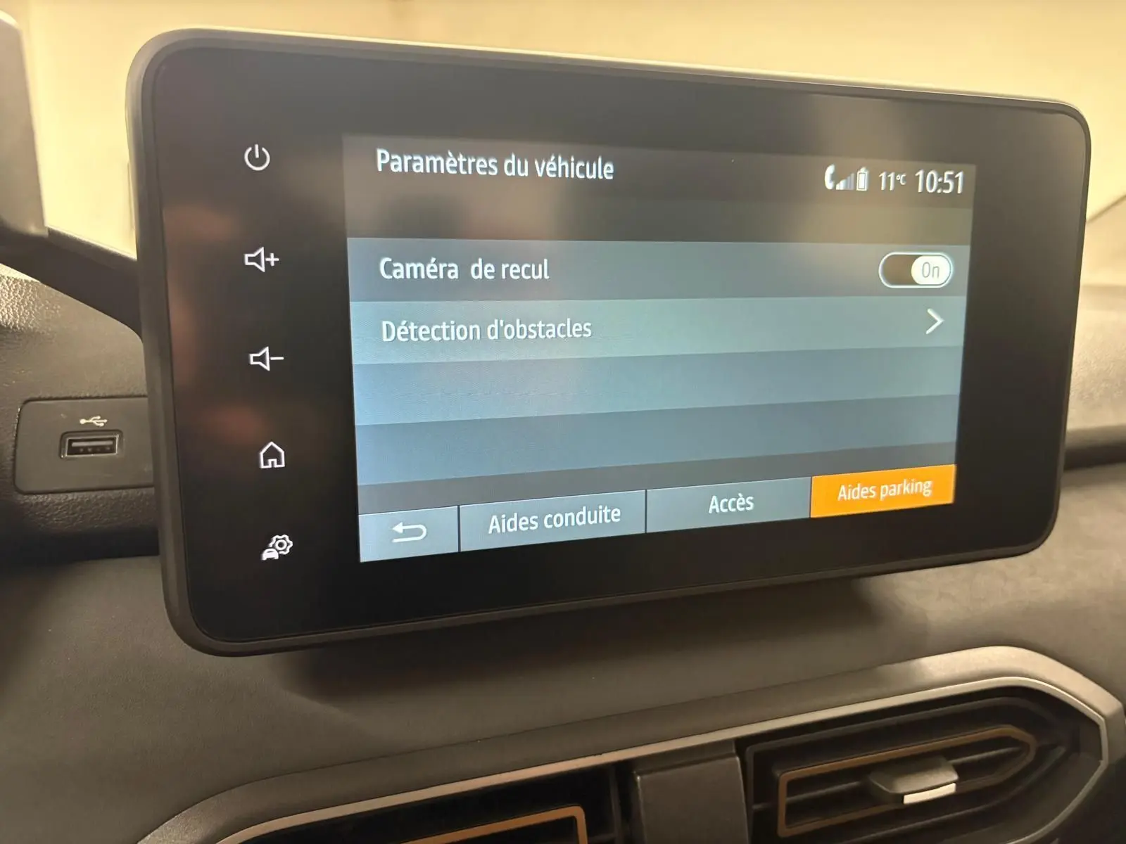 Écran tactile central du tableau de bord du Dacia Sandero Stepway 2023 affichant les paramètres d’aide au stationnement.