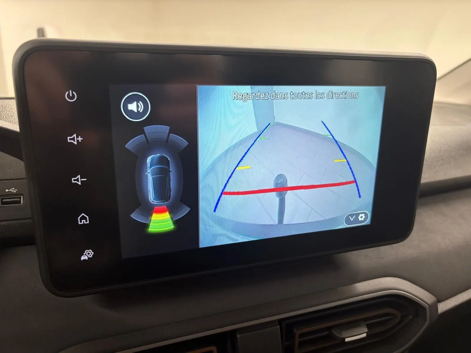 Écran multimédia montrant la caméra de recul et l’attelage du Dacia Sandero Stepway Vert Cèdre, vue intérieure.