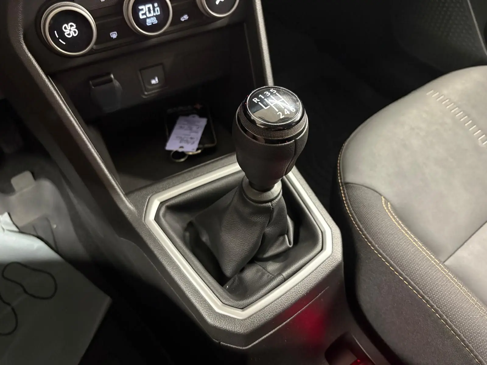 Gros plan sur le levier de vitesses manuel de la Dacia Sandero Stepway 2023, avec console centrale et siège côté droit visibles.