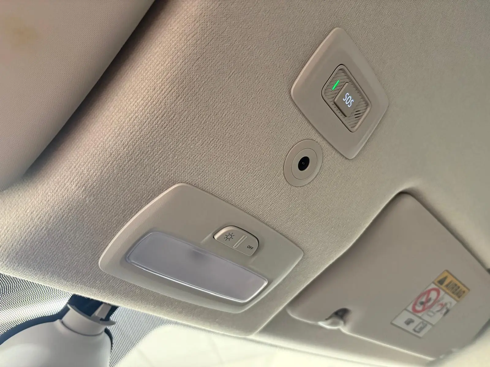 Vue intérieure du plafond de la DACIA Sandero Stepway 2023 avec bouton SOS et éclairage, finition claire.