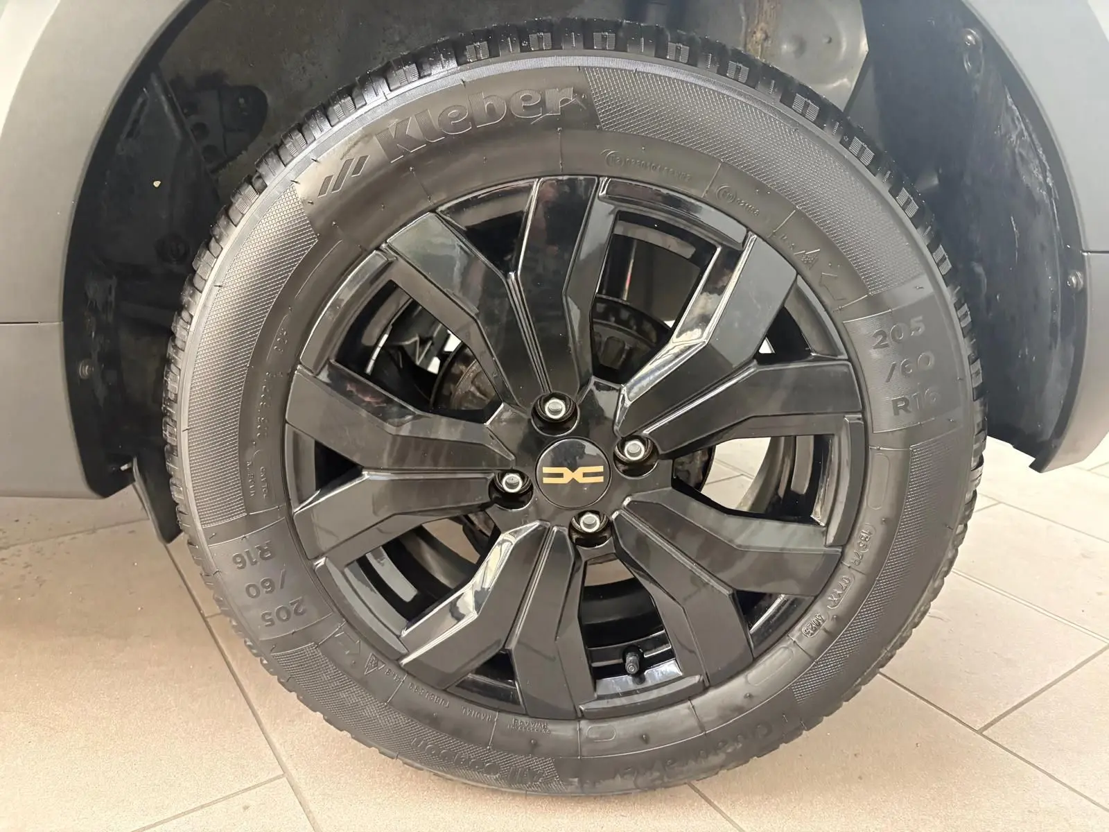 Gros plan sur la roue avant droite noire brillante du Dacia Sandero Stepway Vert Cèdre 2023 avec logo central doré.