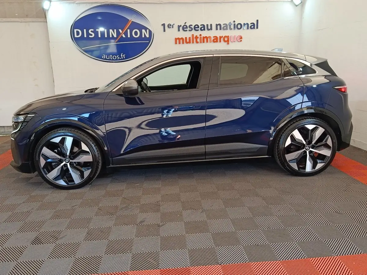 Profil côté gauche de la Renault Mégane Techno EV60 bleu électrique 2023 avec jantes modernes et toit clair.