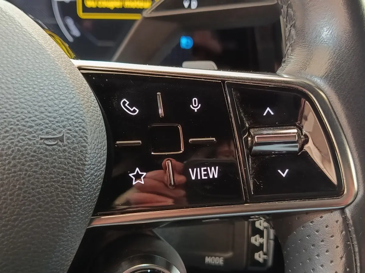Gros plan sur les commandes tactiles noires du volant cuir de la Renault Mégane électrique 2023.