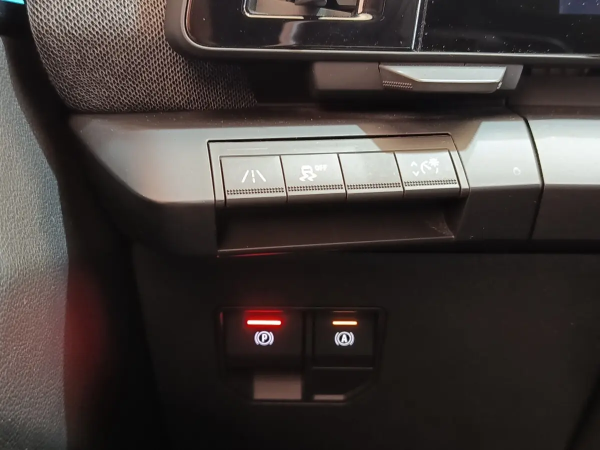 Gros plan sur les commandes de sécurité et assistance au freinage de la Renault Mégane Techno EV60 bleu.