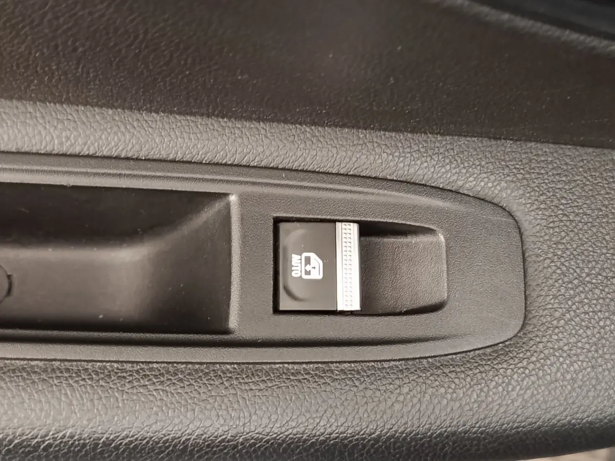 Gros plan sur le bouton de verrouillage des vitres arrière dans l'habitacle noir d'une Renault Mégane électrique 2023.