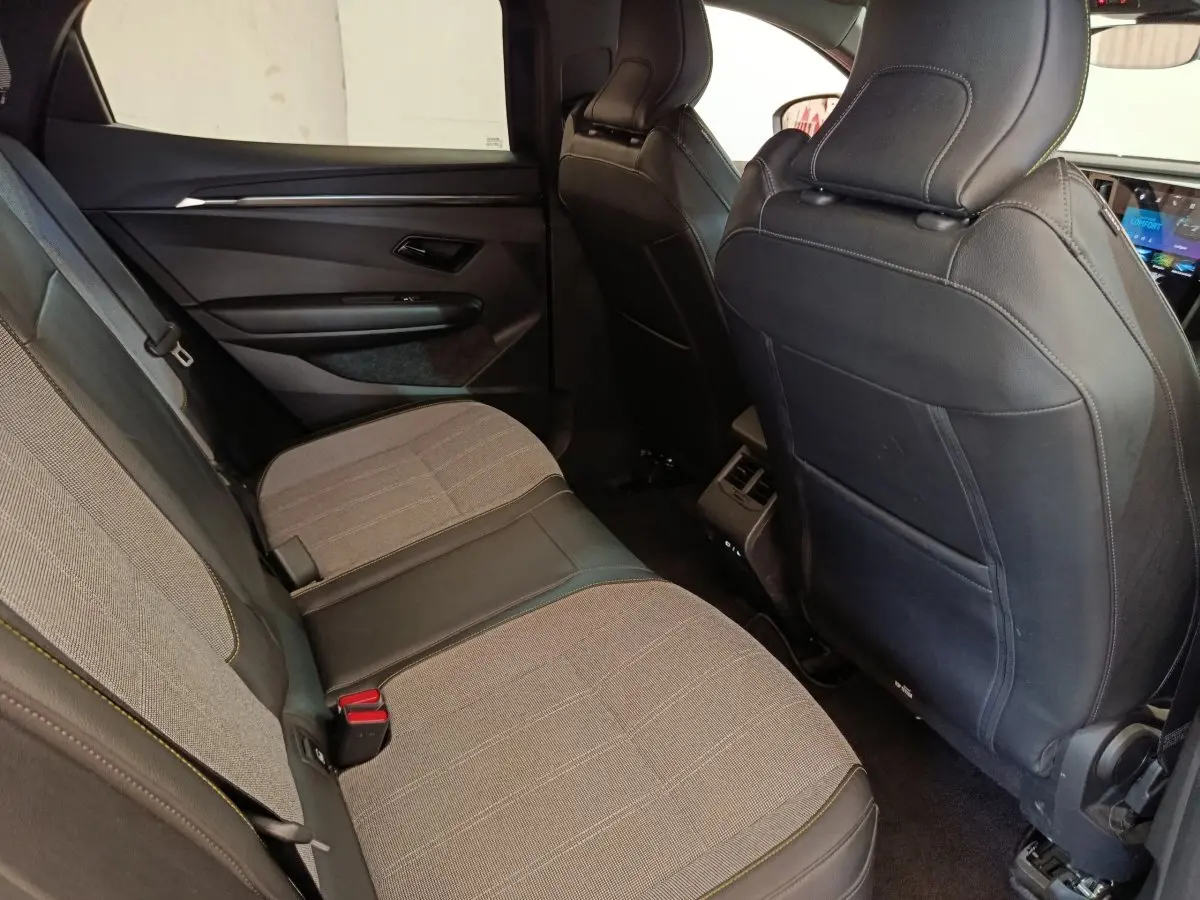 Vue intérieure arrière côté gauche de la Renault Mégane Techno EV60 220ch avec sièges tissu et cuir gris foncé.