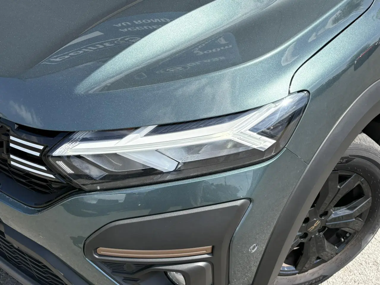 Gros plan sur l'avant droit vert cèdre du Dacia Sandero Stepway 2025 avec phares LED et jante noire.