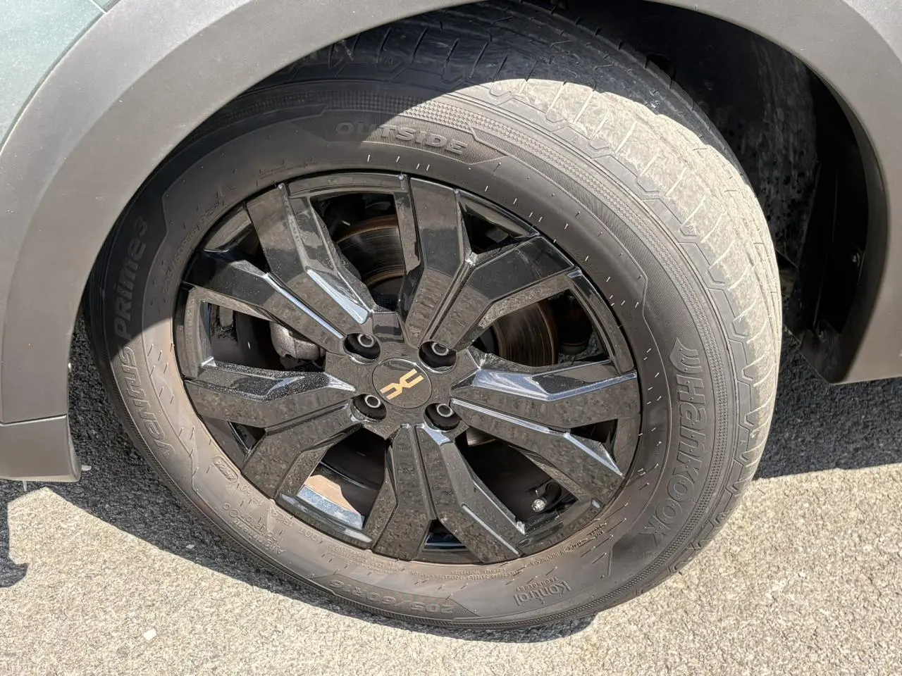Gros plan sur la jante noire 16" Mahalia avec logo Dacia brun cuivré du Dacia Sandero Stepway Vert Cèdre côté droit.