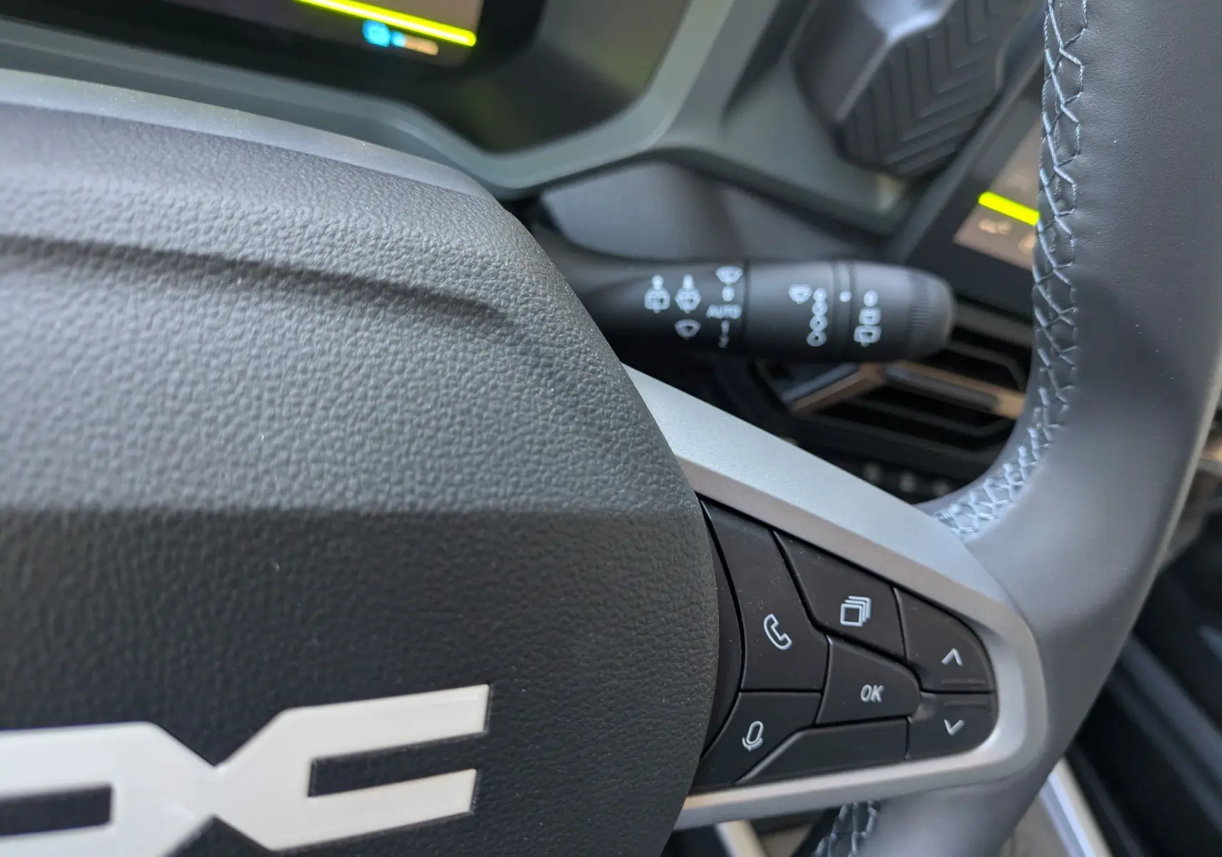 Gros plan sur le volant du Dacia Bigster Hybrid 155 Extreme, montrant les commandes multifonctions à droite.