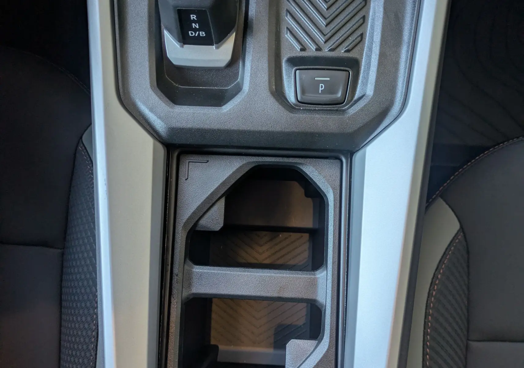 Vue plongeante sur la console centrale de la Dacia Bigster Hybrid 155 Extreme, avec levier de boîte auto et rangement noir.