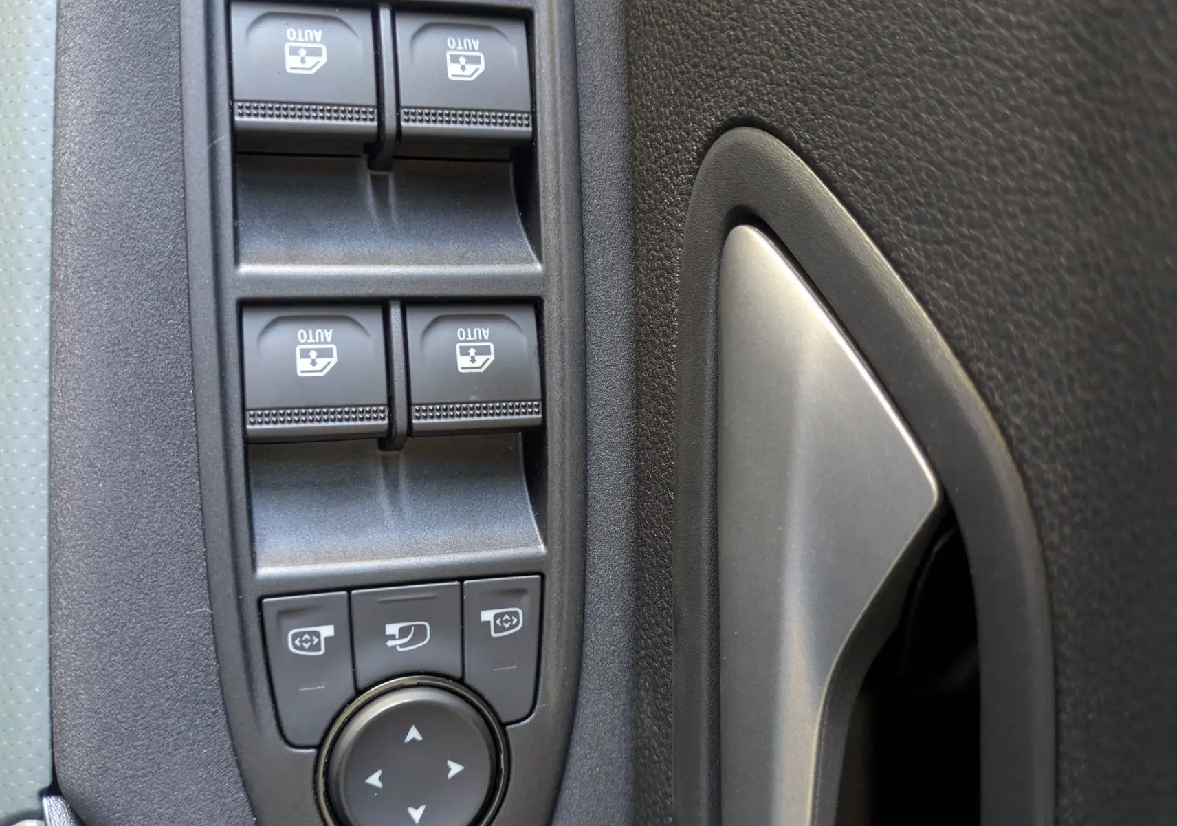 Détail des commandes des vitres et rétroviseurs sur la porte intérieure côté conducteur du Dacia Bigster Hybrid 155 Extreme.