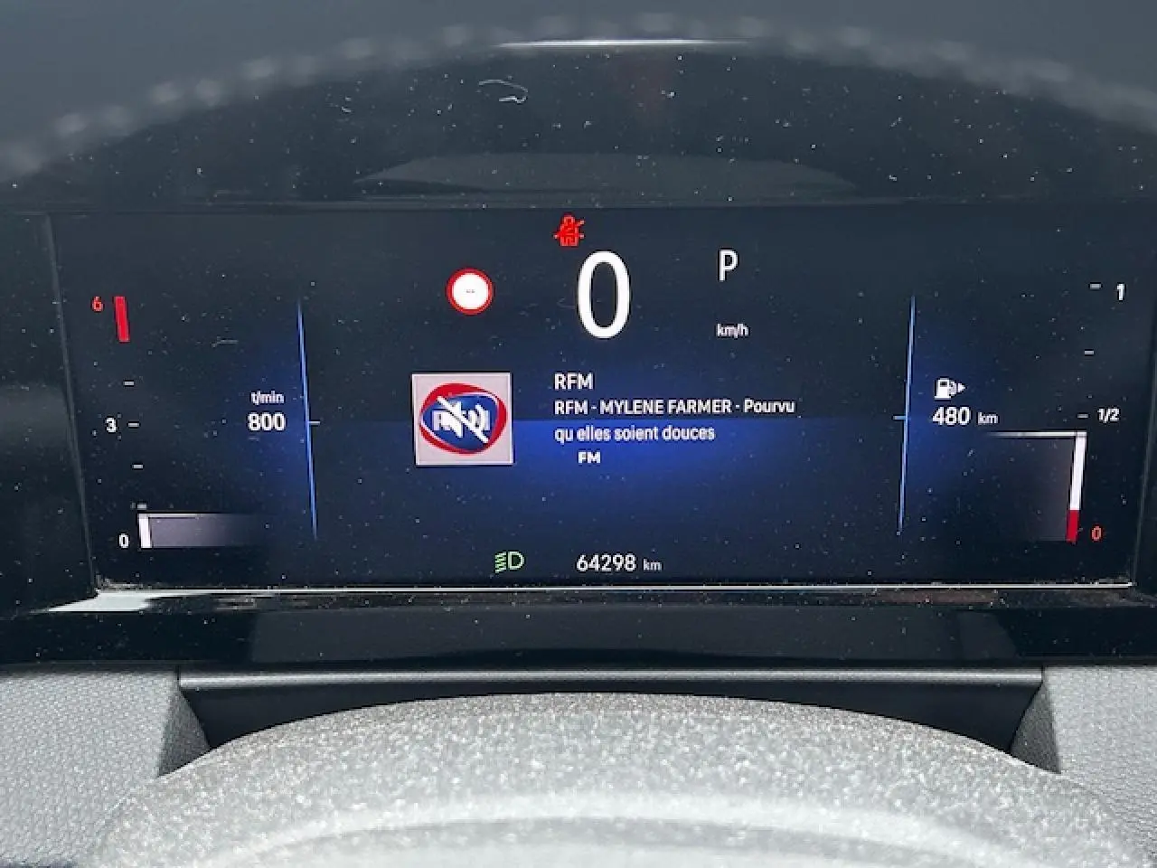 Tableau de bord numérique de l'Opel Astra VI diesel, affichant vitesse zéro et autonomie 480 km.