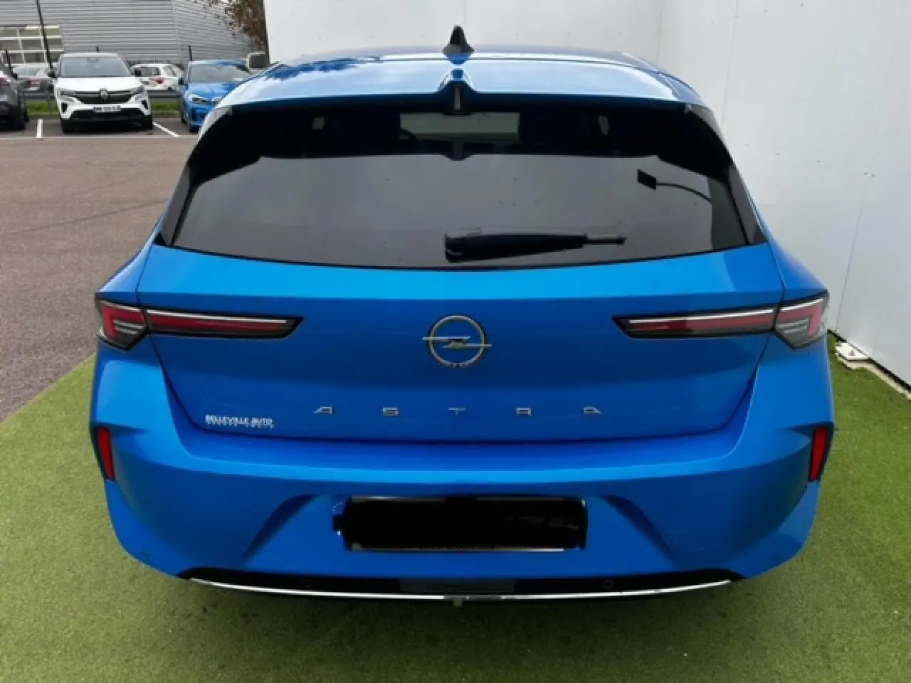 Vue arrière d'une Opel Astra bleu clair 2022 avec feux arrière LED étirés et vitre arrière surteintée.