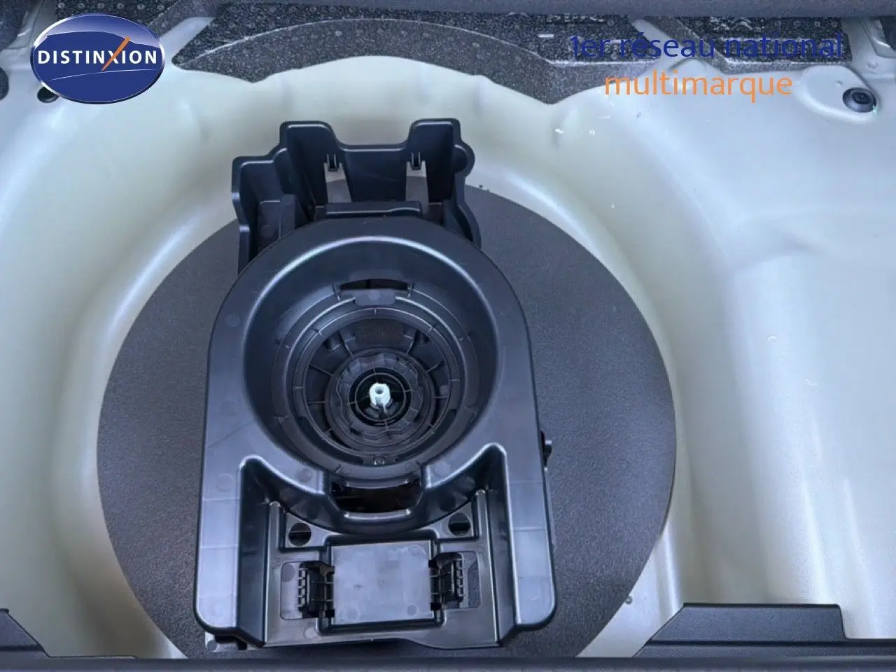 Gros plan sur le logement de la roue de secours dans le coffre d'une Peugeot 208 gris Artense métal 2025.