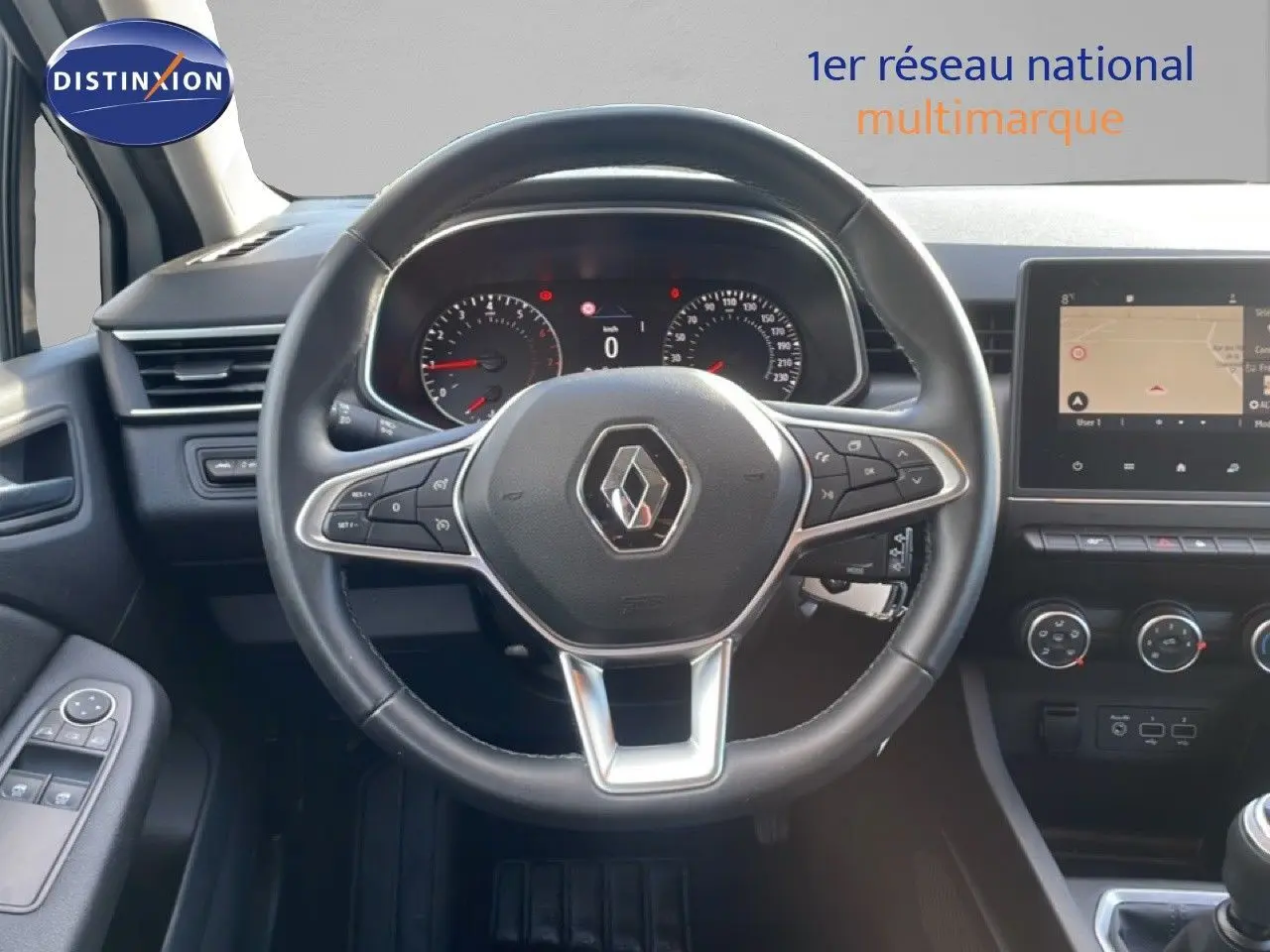 Vue intérieure centrée sur le volant Renault d'une Clio 2020 avec tableau de bord et écran tactile visibles.