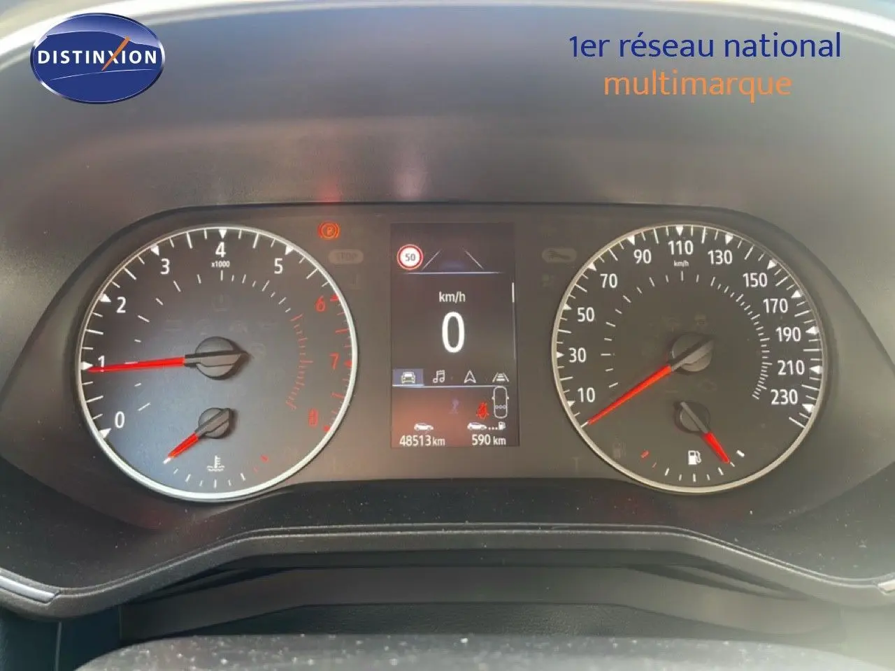 Tableau de bord de Renault Clio blanc glacier 2020, affichage numérique au centre avec compte-tours et compteur de vitesse analogiques.