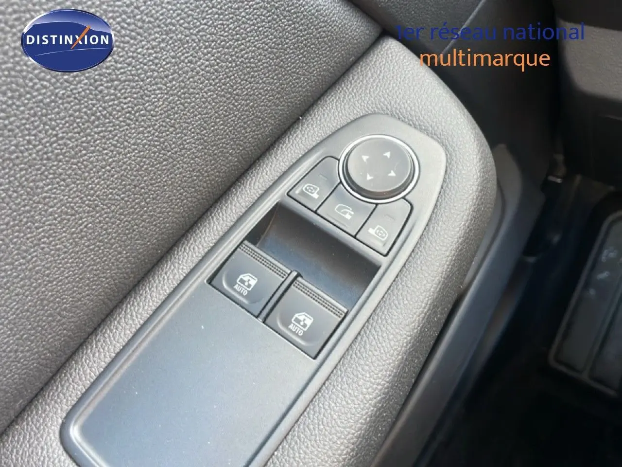 Gros plan sur les commandes de lève-vitres et réglage des rétroviseurs côté conducteur de la Renault Clio blanche Glacier 2020.