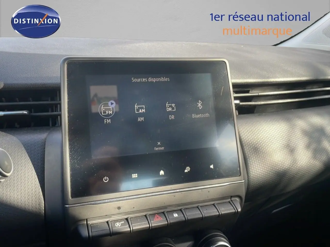 Écran tactile central affichant les sources audio dans l’habitacle d’une Renault Clio blanche glacier 2020.