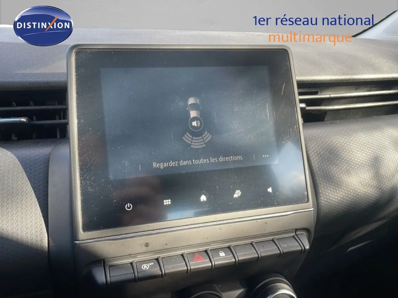 Écran tactile central avec affichage du système d'alerte de proximité sur Renault Clio blanc glacier, vue intérieure avant.