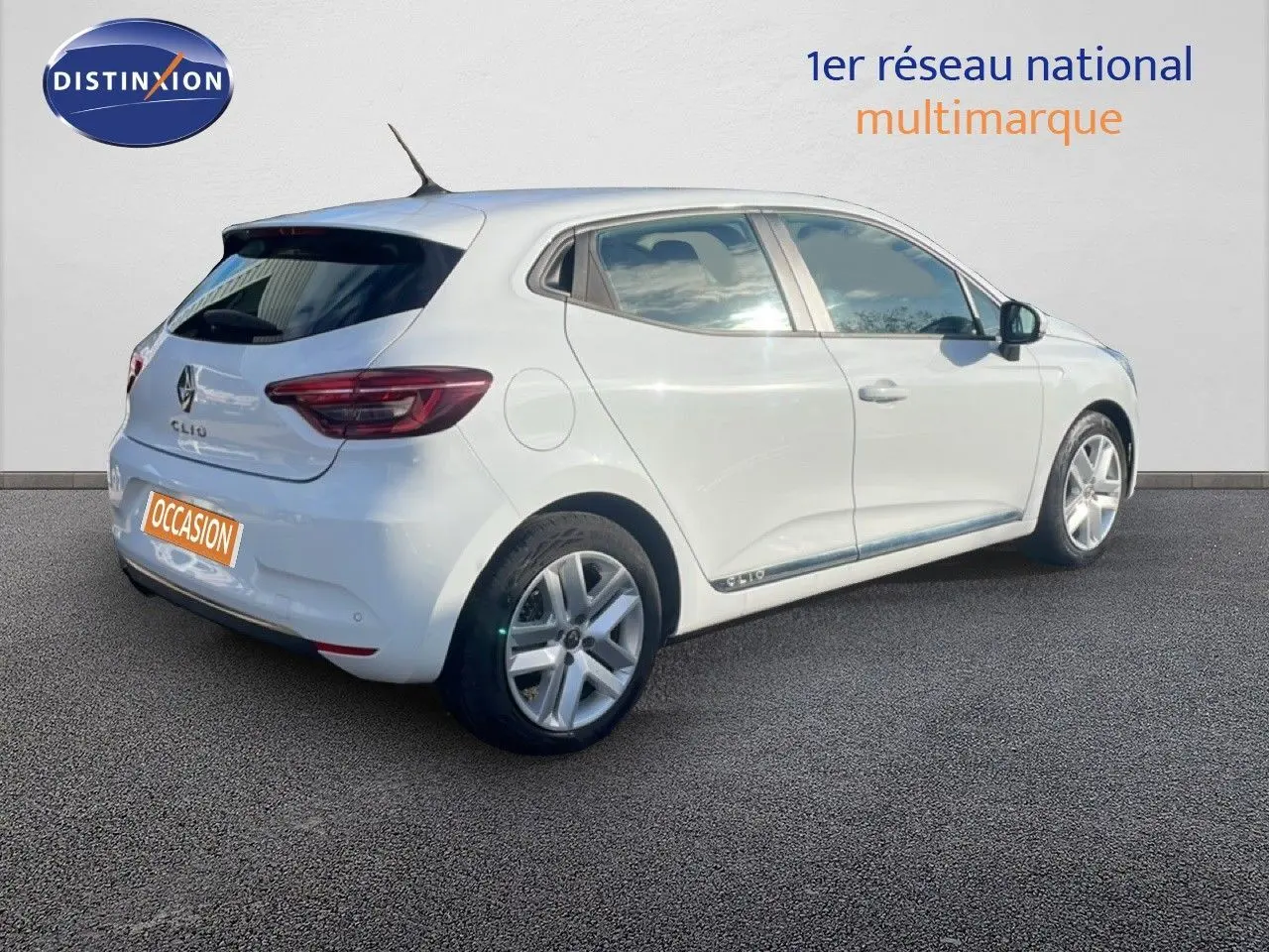 Renault Clio blanc glacier vue 3/4 arrière côté droit, compacte cinq portes avec jantes alliage et feux arrière LED.