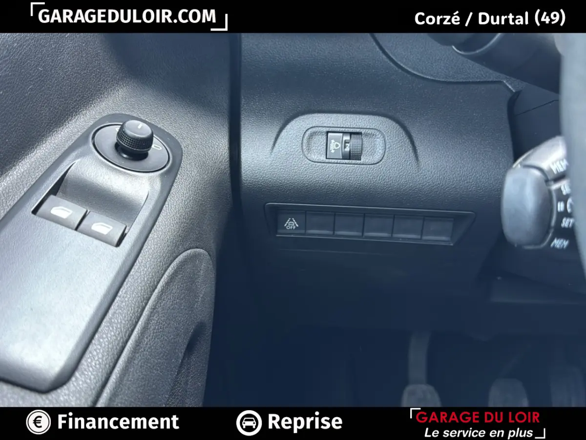 Détail intérieur côté gauche du Peugeot Rifter 2024 bleu, avec commandes des vitres et réglage des phares.