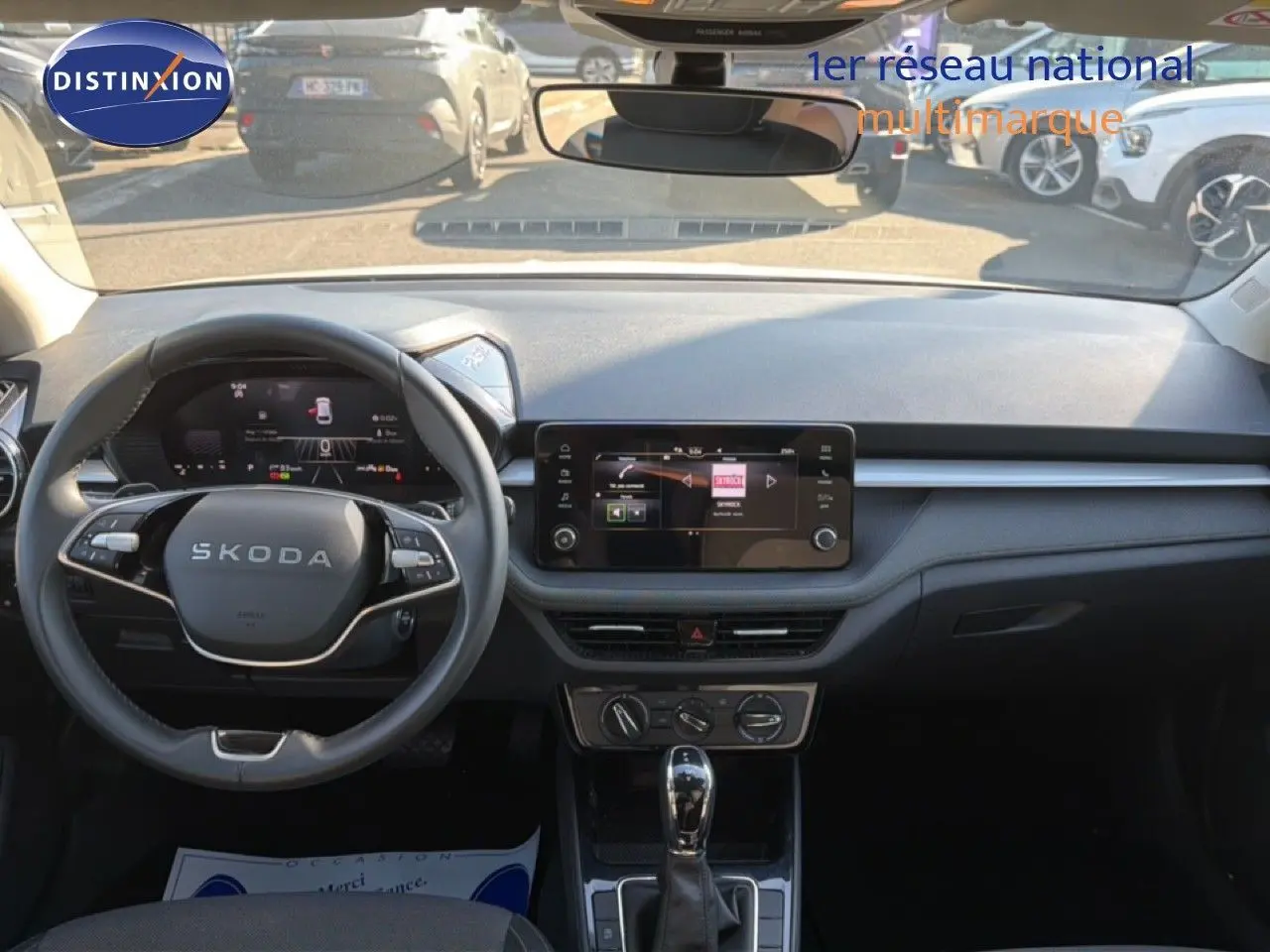 Vue intérieure frontale du tableau de bord et volant noir d'une Skoda Fabia 2025 avec écran tactile central et boîte automatique.