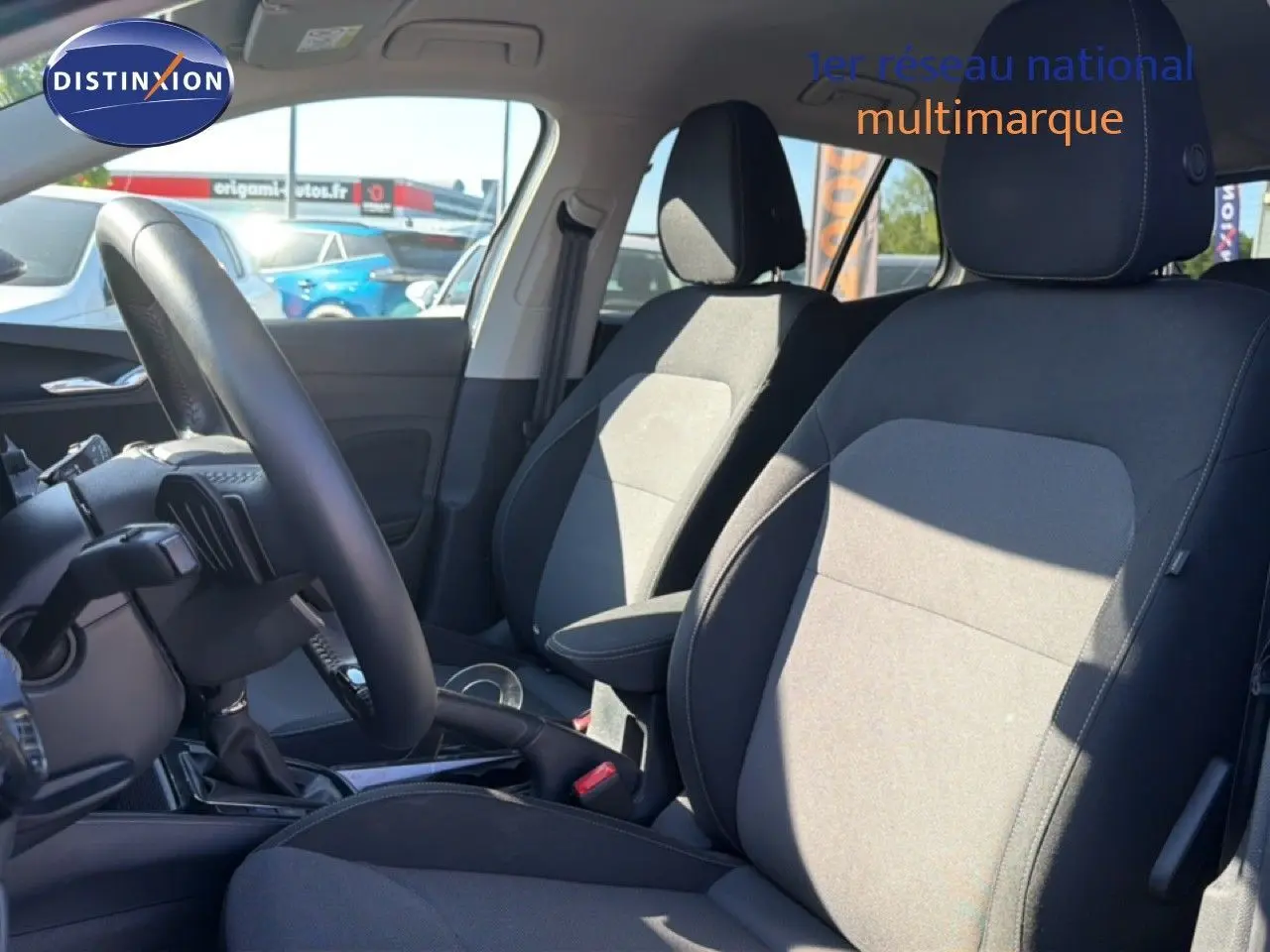 Vue intérieure côté gauche de la Skoda Fabia 2025, sièges tissu noir et gris avec volant cuir multifonction.