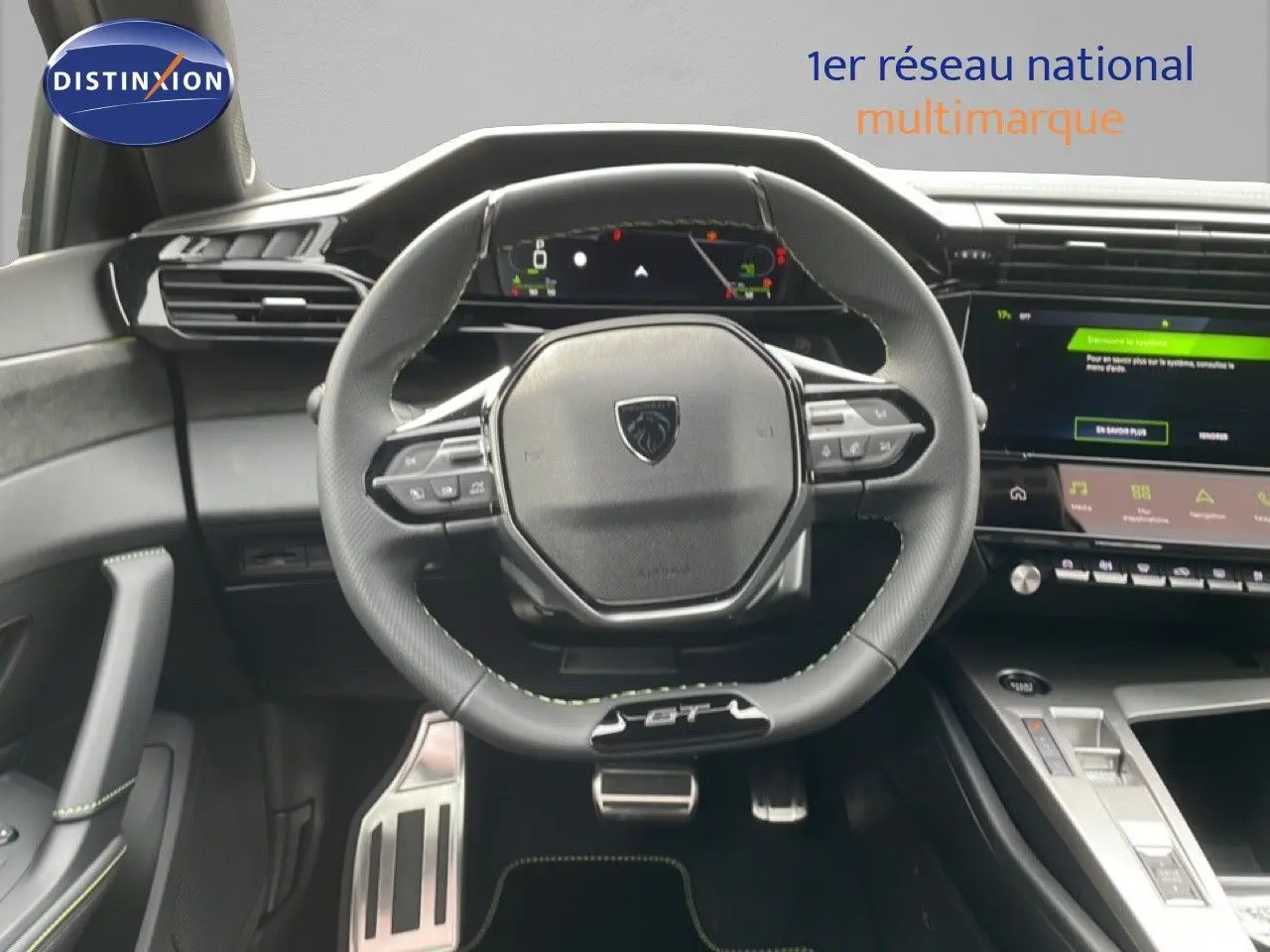 Intérieur Peugeot 308 GT 2026, vue centrée sur le volant cuir noir avec surpiqûres vertes et tableau de bord numérique.