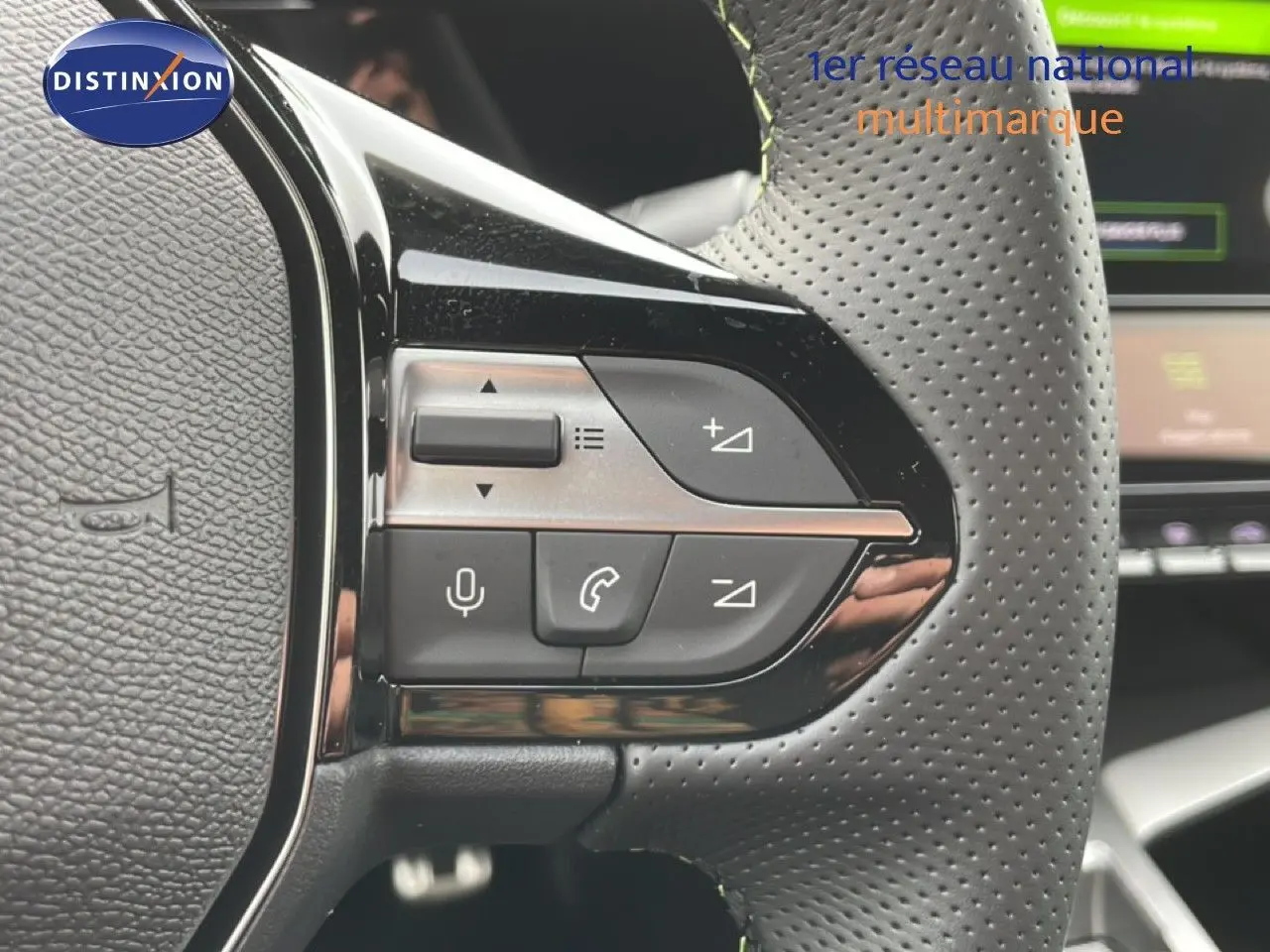Gros plan sur les commandes gauche du volant en cuir perforé du Peugeot 308 gris Selenium Hybrid 2026.