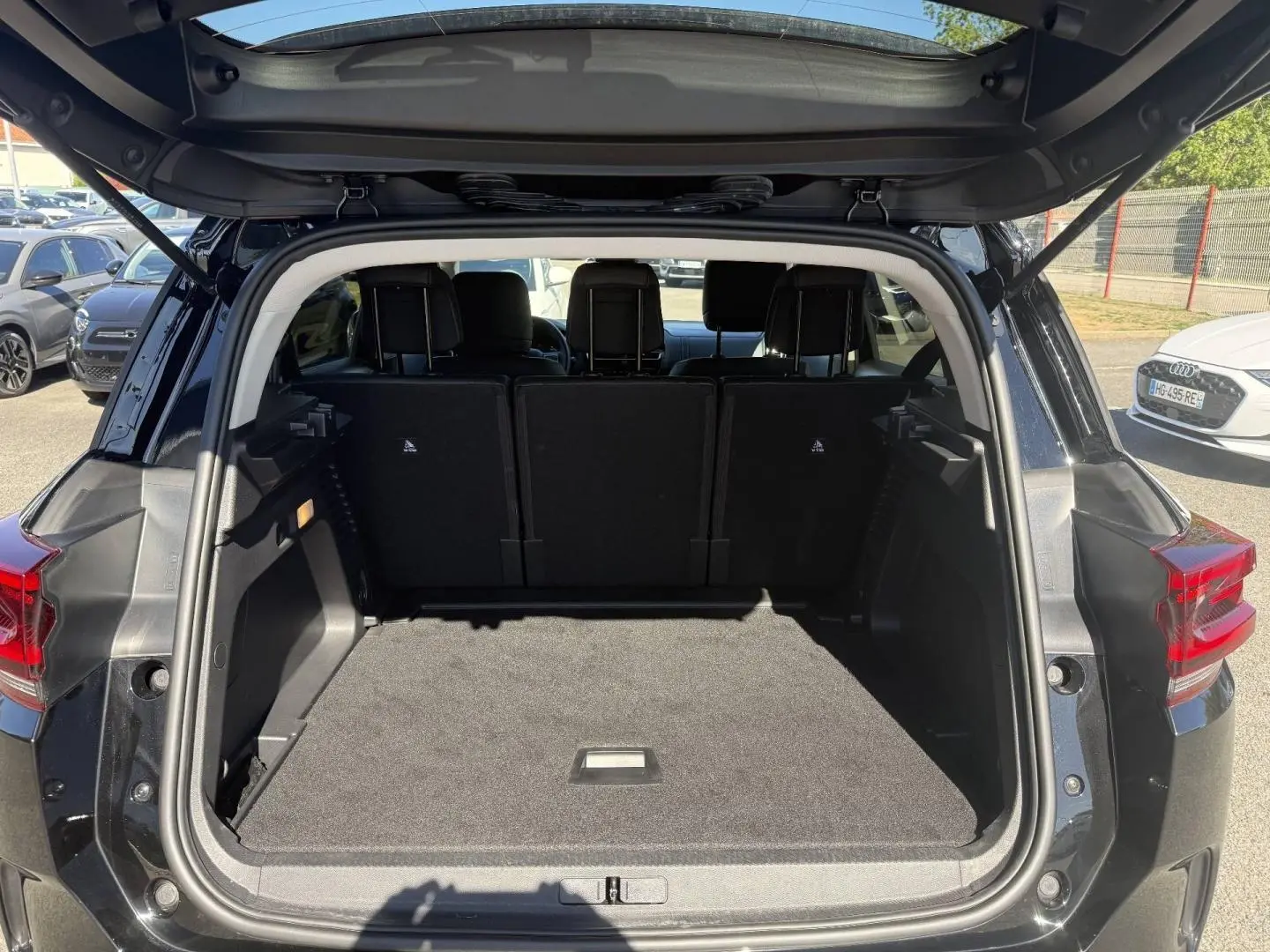 Coffre ouvert vu de l'arrière d'un Citroën C5 Aircross noir Perla Nera avec sièges arrière en place.