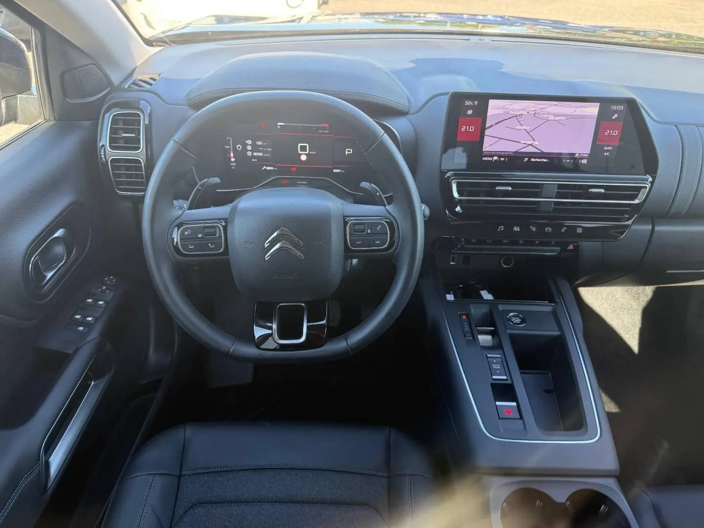 Vue intérieure frontale du poste de conduite noir du Citroën C5 Aircross avec écran tactile et volant multifonction.