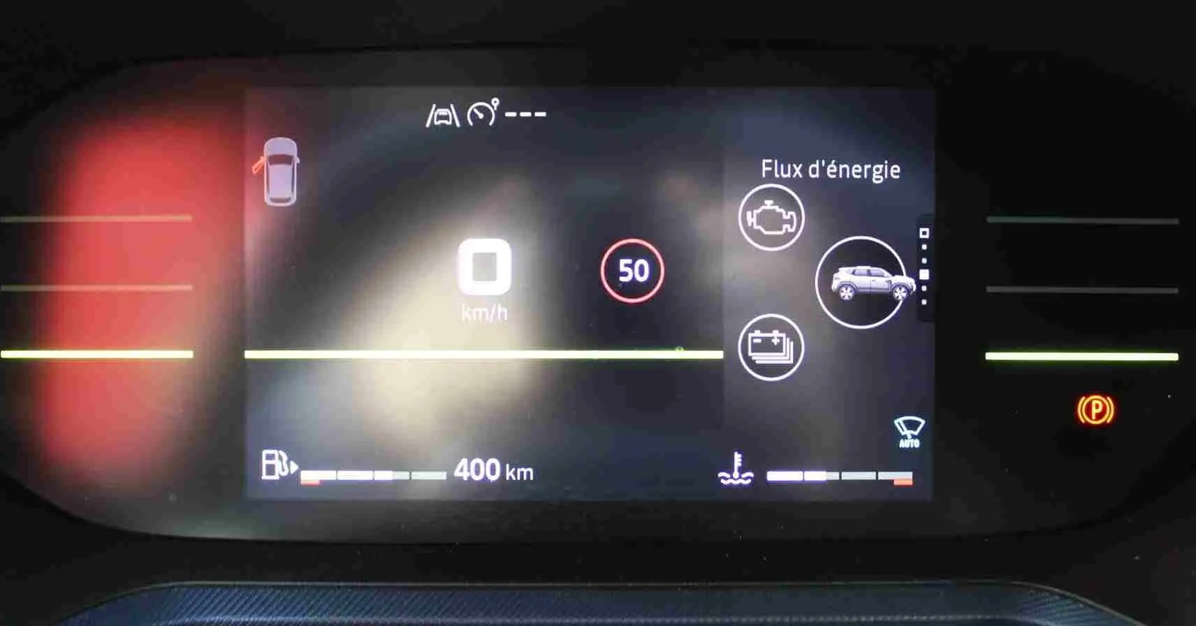 Tableau de bord digital du Dacia Duster 2025 affichant la vitesse, autonomie et flux d'énergie hybride.