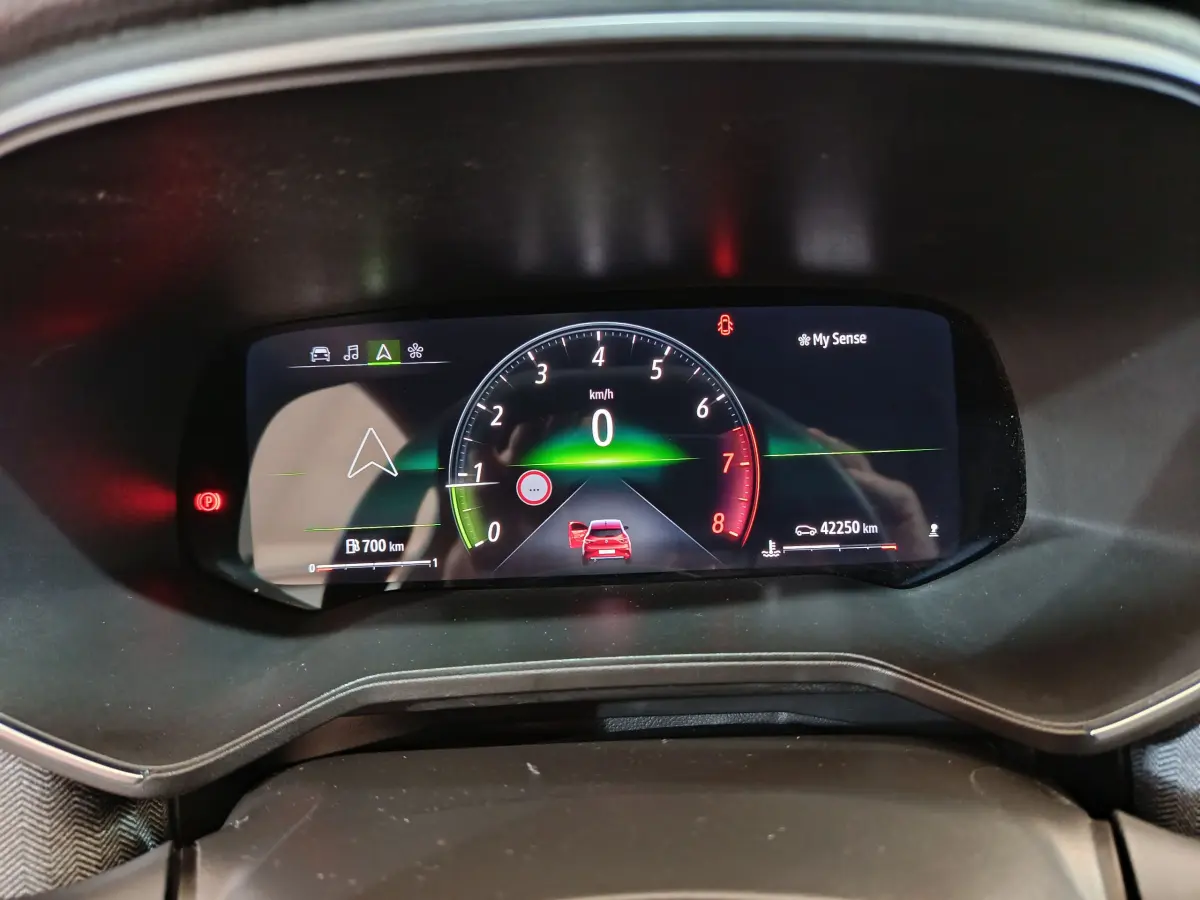 Affichage numérique du combiné d'instruments de la Renault Clio rouge 2024, vitesse à zéro et navigation active.