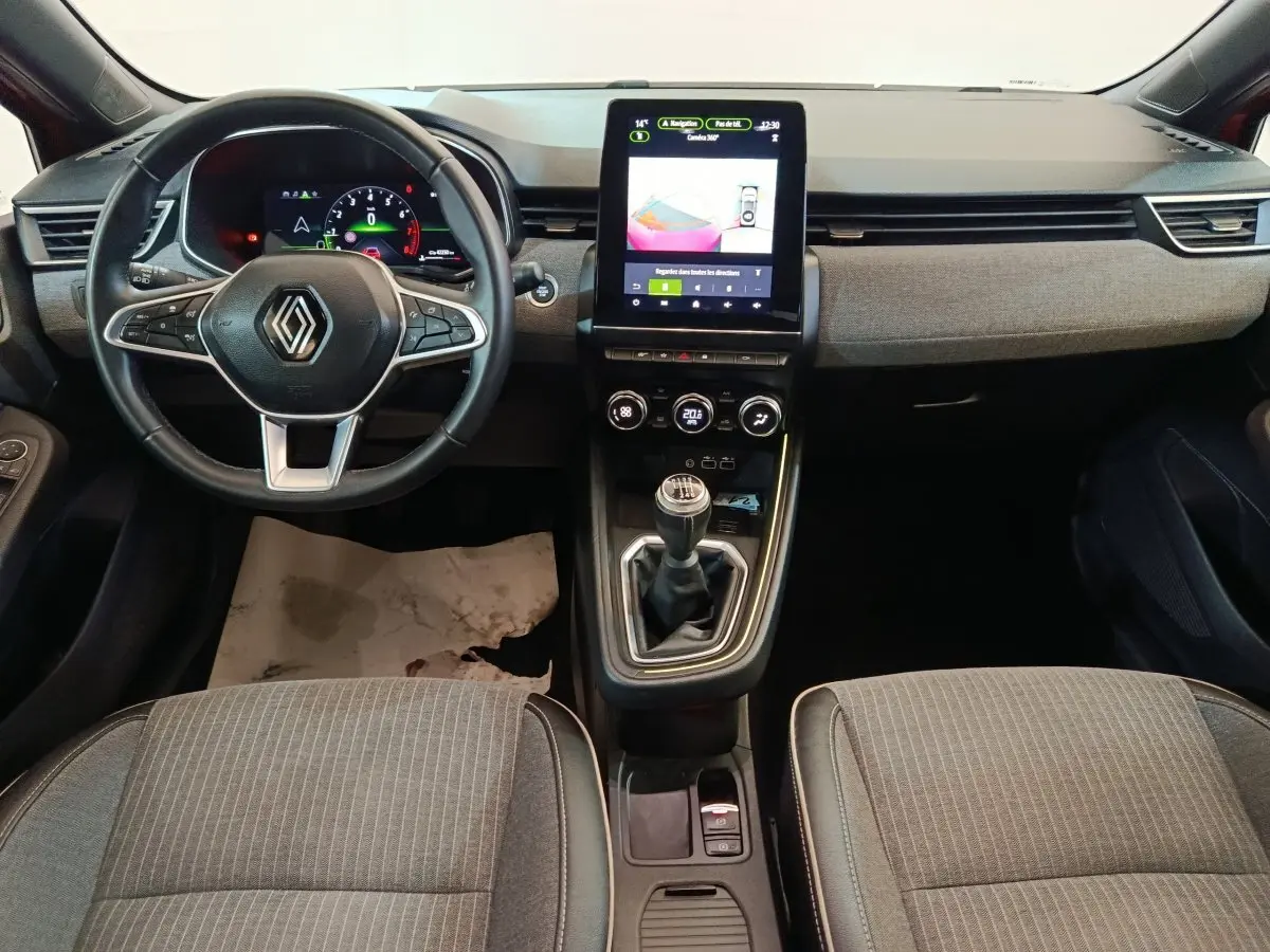 Vue frontale de l'habitacle de la Renault Clio Techno TCe 90 2024, volant cuir, écran tactile vertical et boîte manuelle.