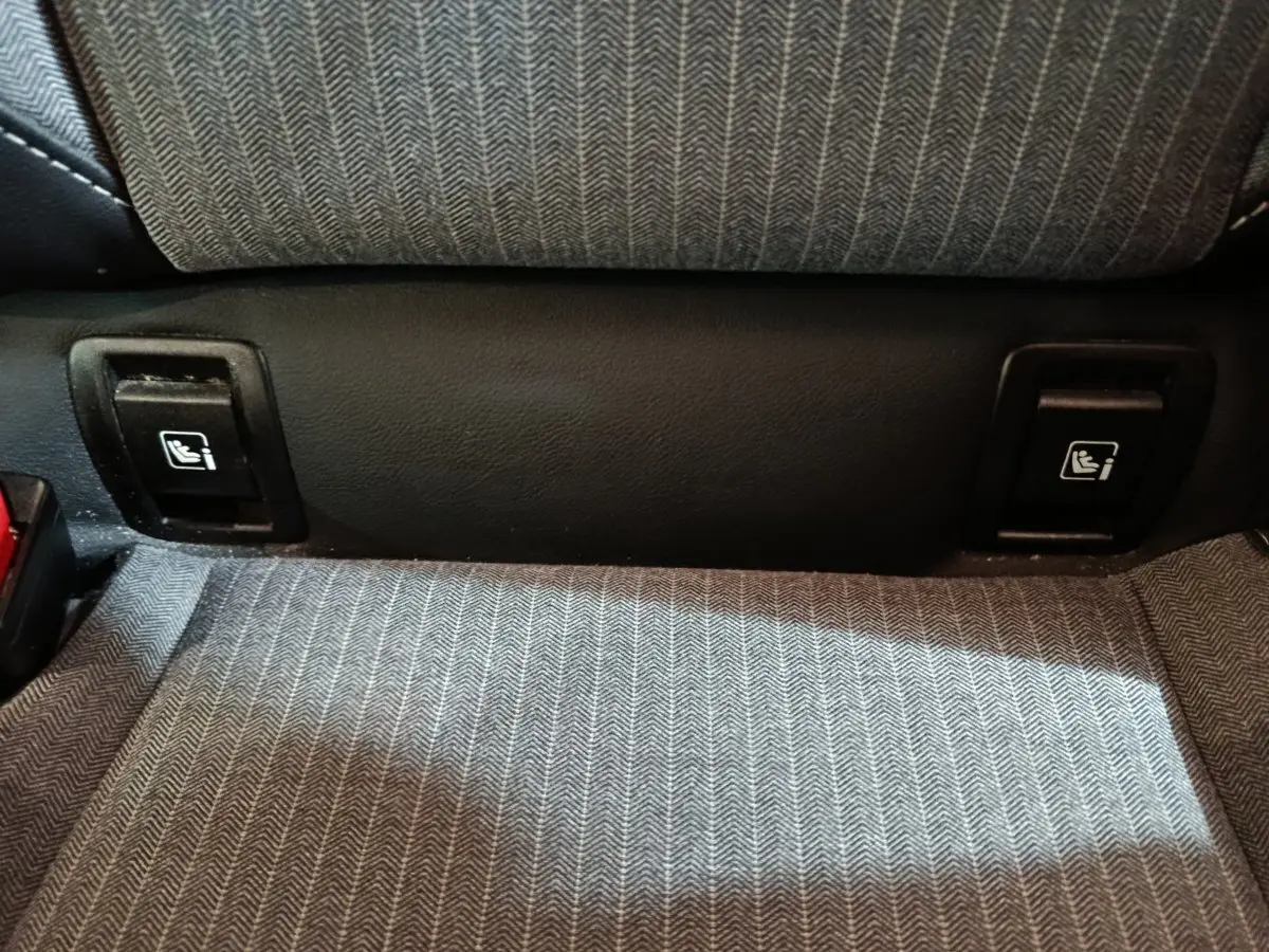 Détail des fixations Isofix sur la banquette arrière en tissu gris de la Renault Clio Techno TCe 90 rouge 2024.